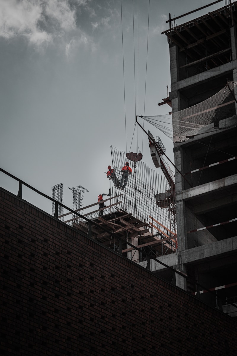 man in red jacket and black pants standing on top of building